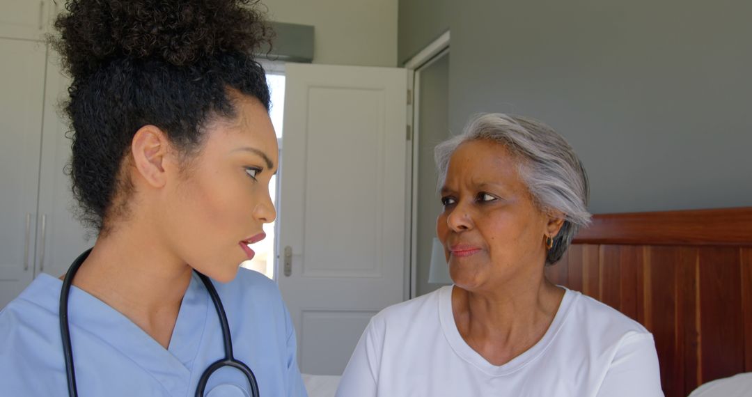 Biracial nurse and senior woman are talking, both looking serious - Free Images, Stock Photos and Pictures on Pikwizard.com