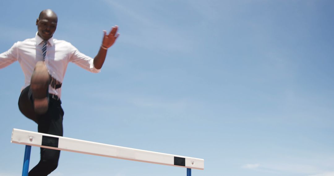 Businessman Jumping Over Hurdle in Athletic Gear - Free Images, Stock Photos and Pictures on Pikwizard.com