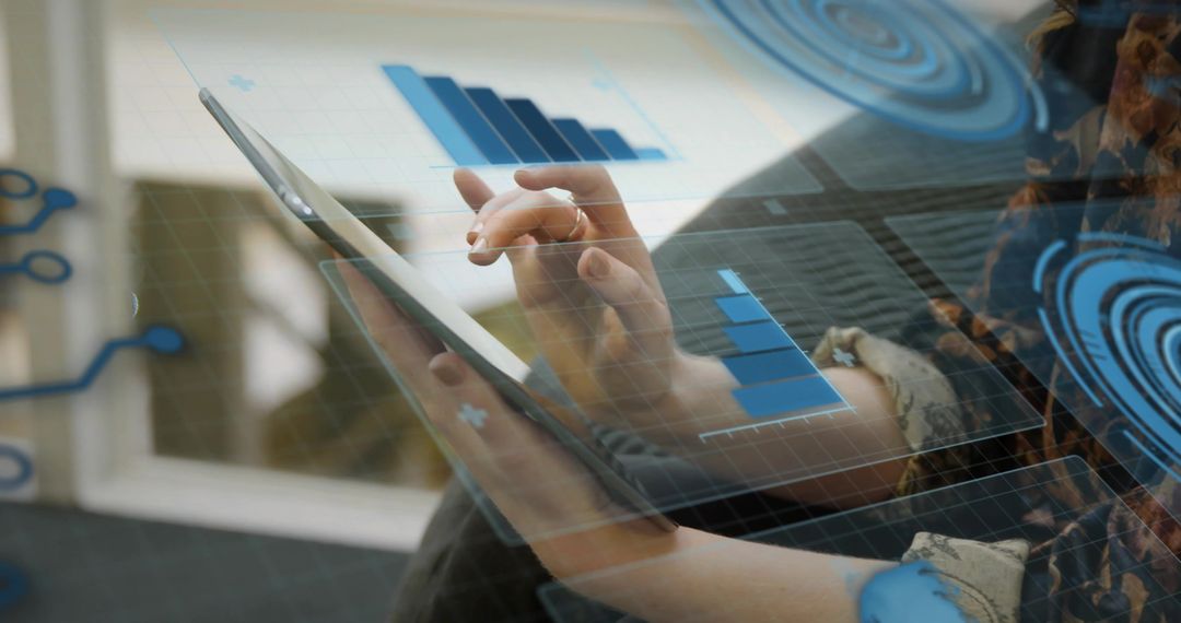 Woman tapping tablet with augmented HUD charts on sofa by window analyzing business data