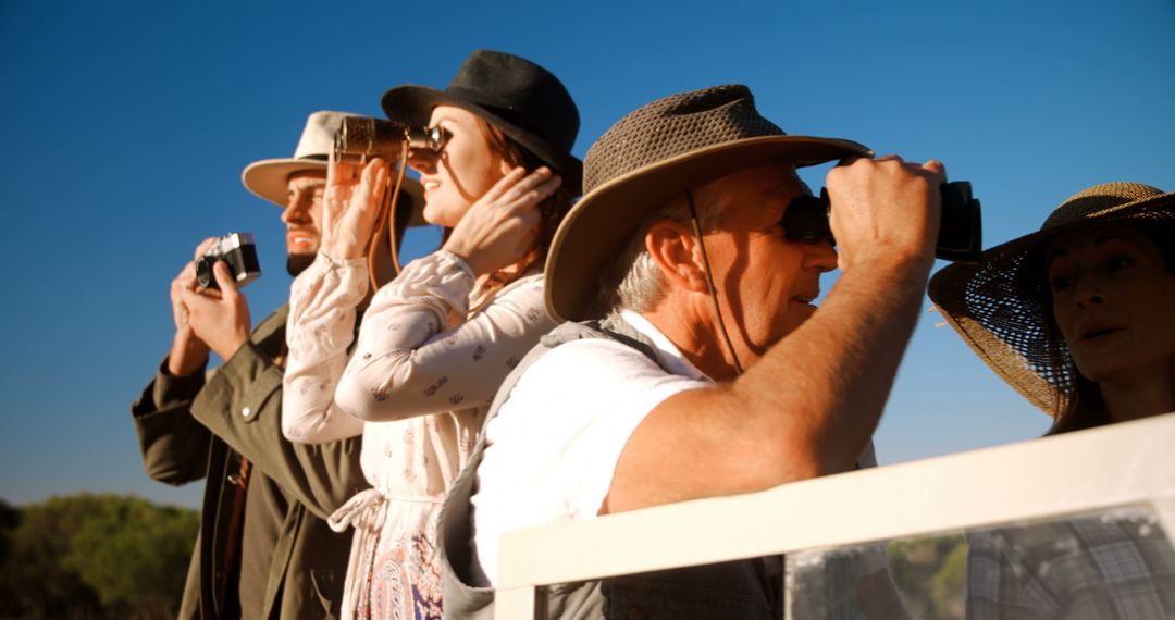 Group of People Bird Watching with Binoculars in Hats Outdoors - Free Images, Stock Photos and Pictures on Pikwizard.com