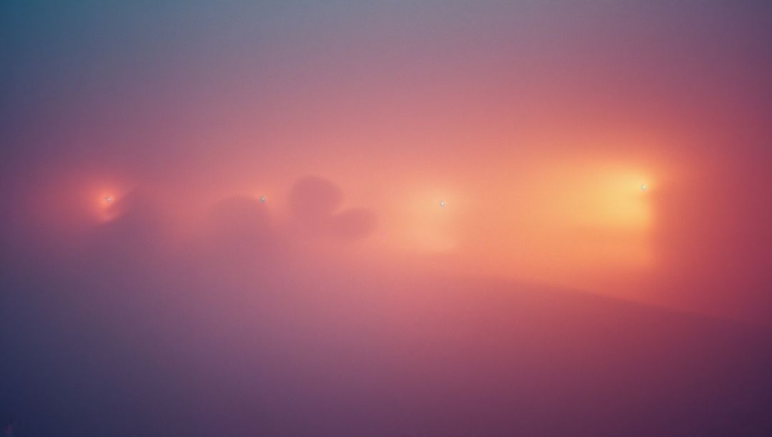 Mystical Dawn Over Misty Mountain Silhouettes with Pastel Fog