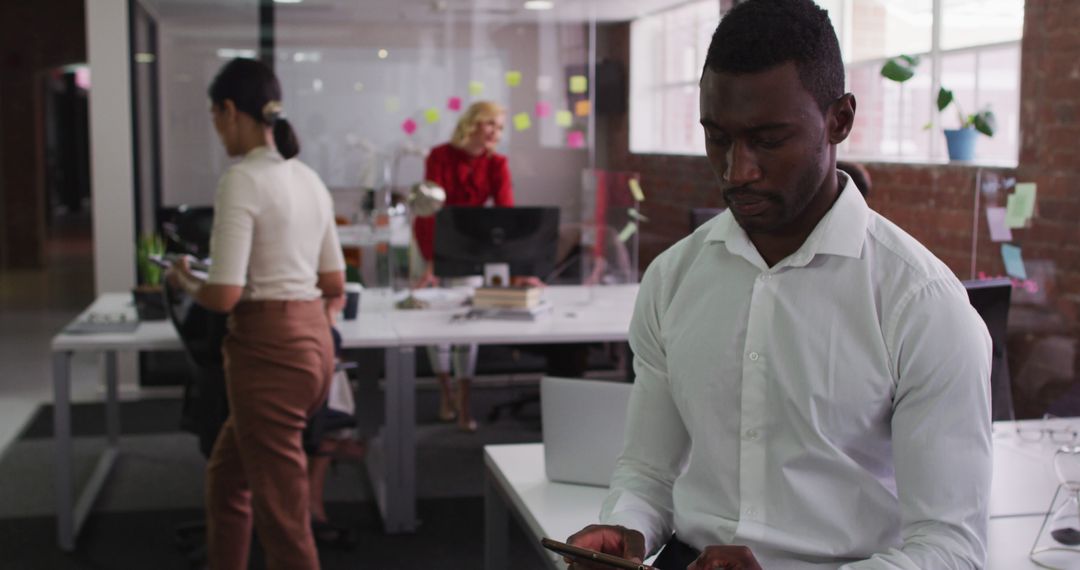 Focused Businessman Using Tablet in Modern Open Office