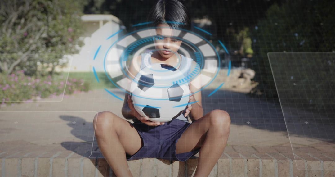 Boy Holding Soccer Ball with Futuristic Digital Overlay in Backyard