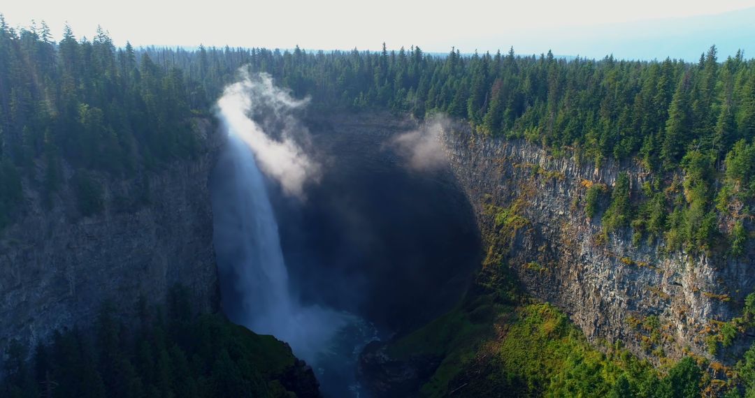 Majestic Waterfall in Lush Forested Canyon at Sunrise - Free Images, Stock Photos and Pictures on Pikwizard.com