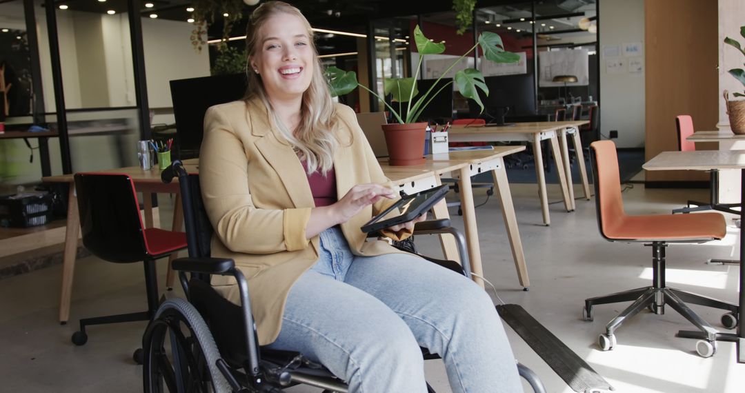 Smiling Businesswoman in Wheelchair Using Digital Tablet in Modern Office - Free Images, Stock Photos and Pictures on Pikwizard.com