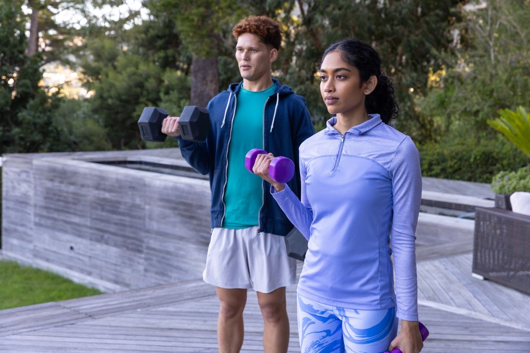 Diverse Workout Partners Lifting Dumbbells Outdoors