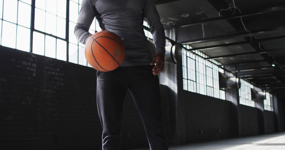 Athlete Holding Basketball in Industrial Gym - Free Images, Stock Photos and Pictures on Pikwizard.com