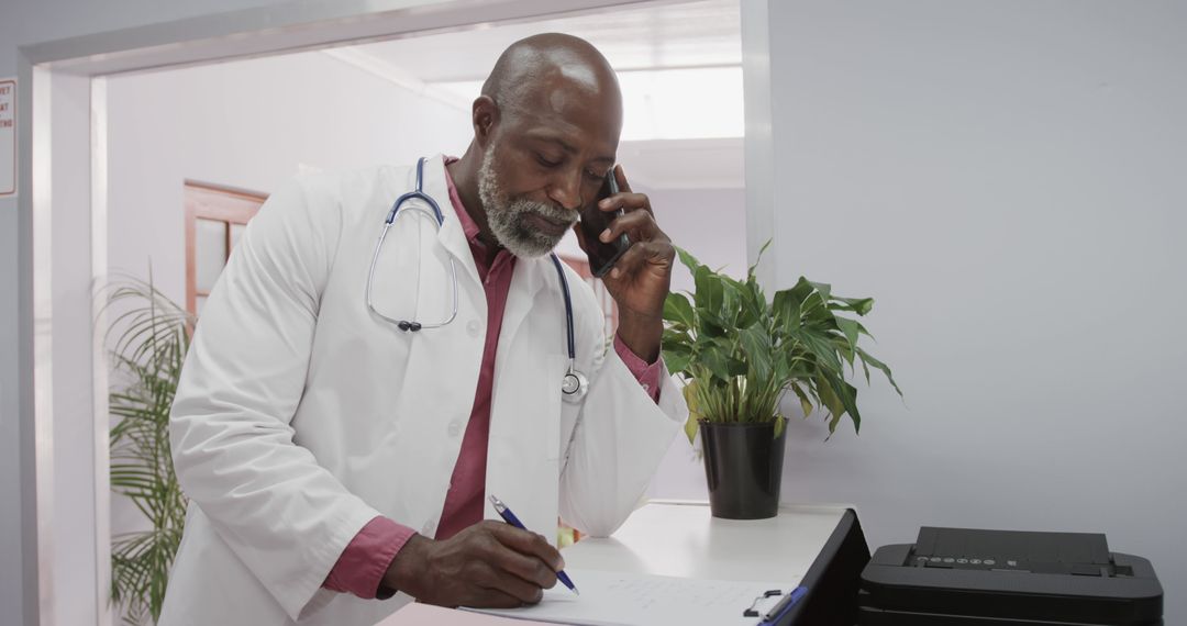 Senior African American Doctor Taking Notes While Talking on Phone - Free Images, Stock Photos and Pictures on Pikwizard.com