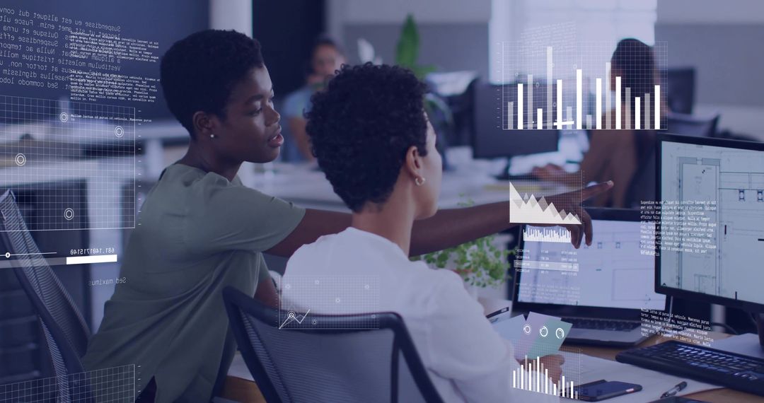 Two coworkers collaborating over data dashboards, analytics and UI design on dual monitors