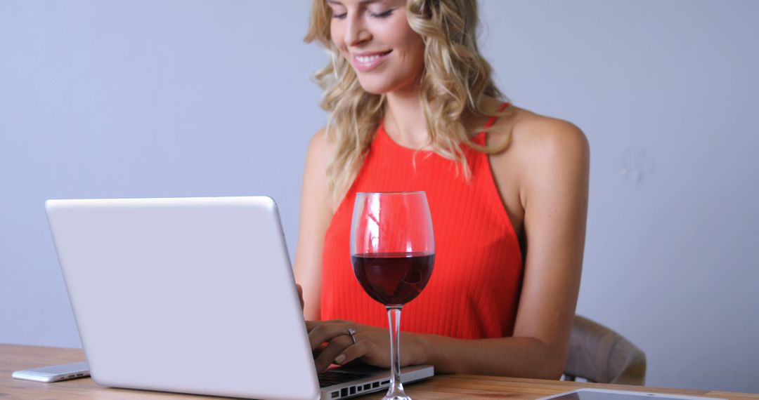 Woman in Red Dress Typing on Laptop with Wine Glass on Desk - Free Images, Stock Photos and Pictures on Pikwizard.com