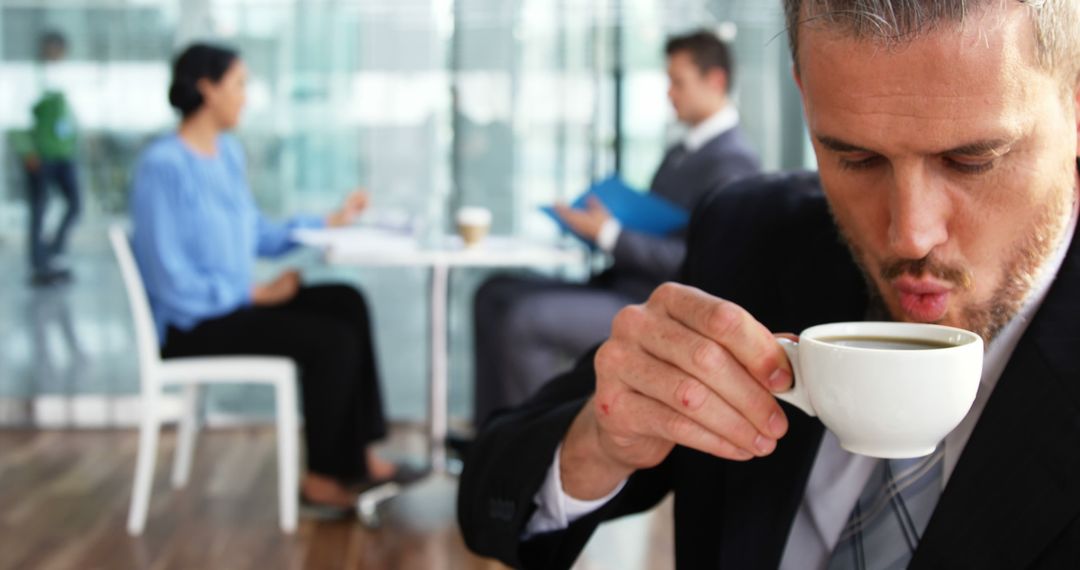 Businessman Drinking Coffee During Office Meeting - Free Images, Stock Photos and Pictures on Pikwizard.com