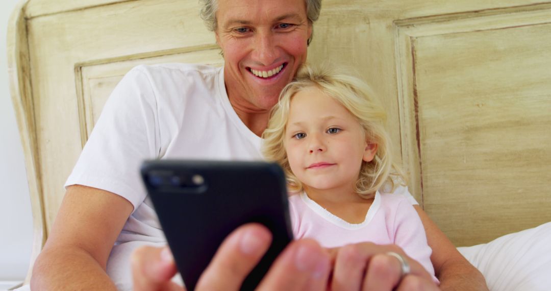 Father and Daughter Spending Quality Time Together on Smartphone at Home - Free Images, Stock Photos and Pictures on Pikwizard.com