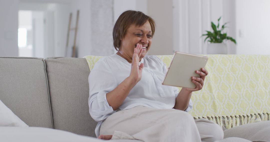 Senior Woman Video Calling Using Tablet on Sofa at Home - Free Images, Stock Photos and Pictures on Pikwizard.com