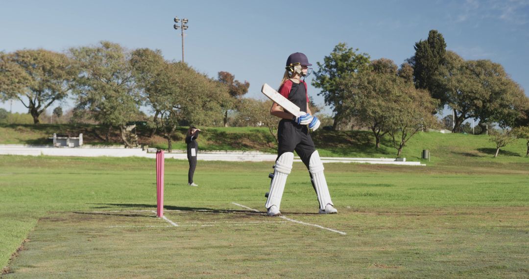 Female Cricket Player Focused on Game in Sunlit Field