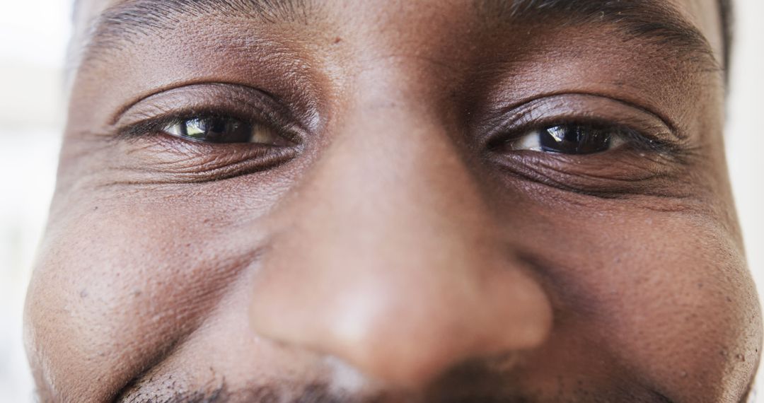 Close-up of African American Man Smiling with Focus on Eyes and Nose - Free Images, Stock Photos and Pictures on Pikwizard.com