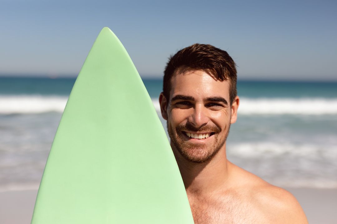 Smiling Young Man with Surfboard on Sunny Beach - Free Images, Stock Photos and Pictures on Pikwizard.com