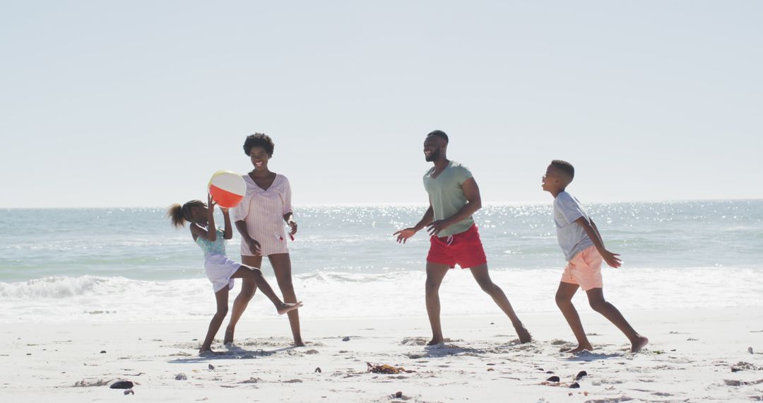 Happy African American Family Playing with Beach Ball at Ocean Shore - Free Images, Stock Photos and Pictures on Pikwizard.com