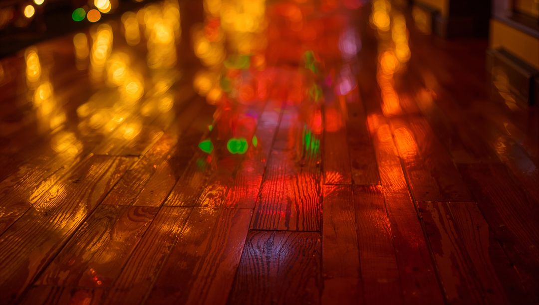 Glowing Holiday Lights Casting Warm Bokeh Reflections on Polished Hardwood Floor