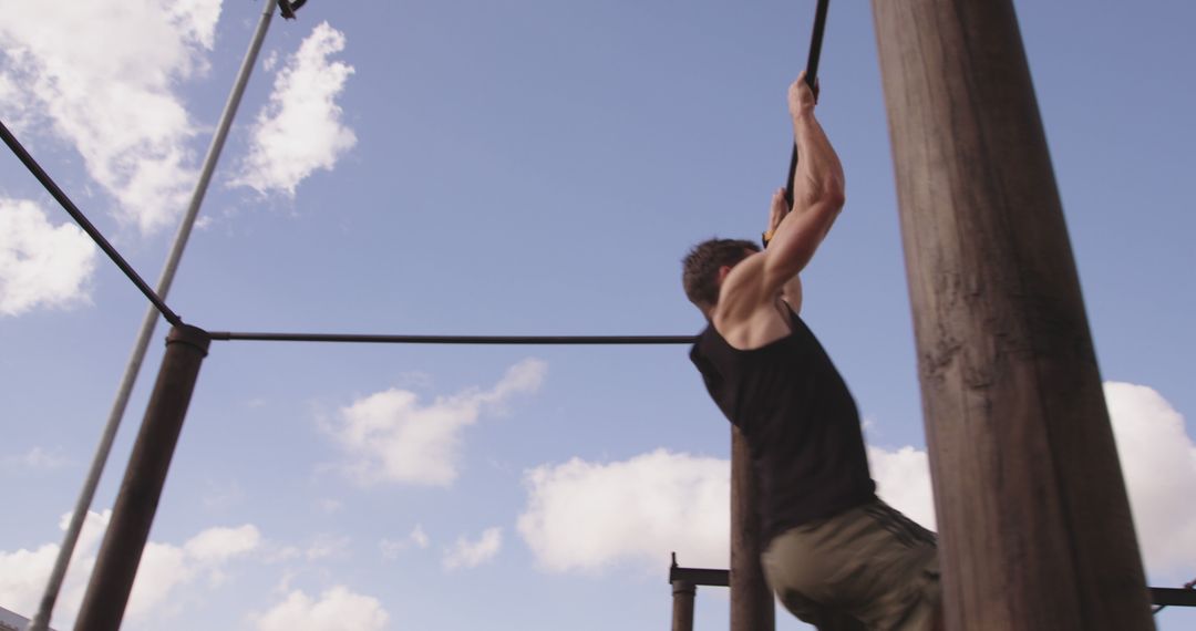 Young Man Climbing Rope in Outdoor Workout Area - Free Images, Stock Photos and Pictures on Pikwizard.com