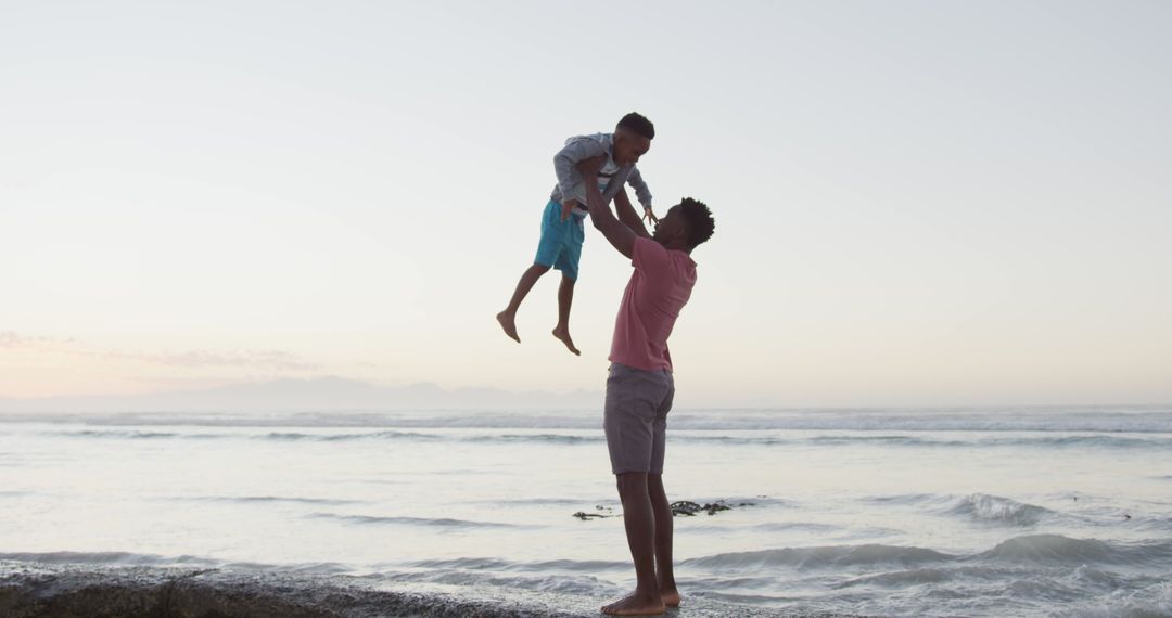 Father Lifting Child on Beach During Sunset - Free Images, Stock Photos and Pictures on Pikwizard.com