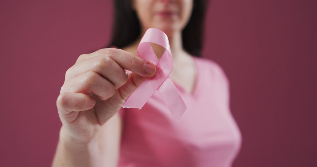 Woman in Pink Shirt Holding Pink Ribbon for Breast Cancer Awareness - Free Images, Stock Photos and Pictures on Pikwizard.com