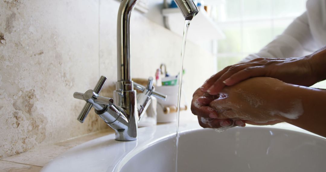 Person Washing Hands Under Running Water in Bathroom - Free Images, Stock Photos and Pictures on Pikwizard.com