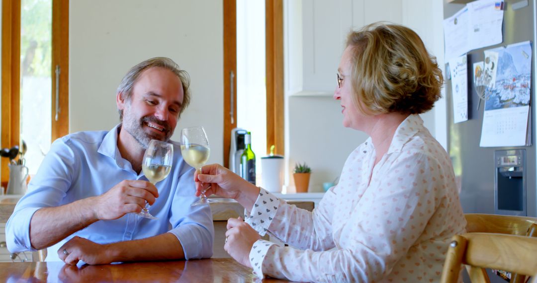 Couple Enjoying Wine and Laughter in Cozy Kitchen Setting