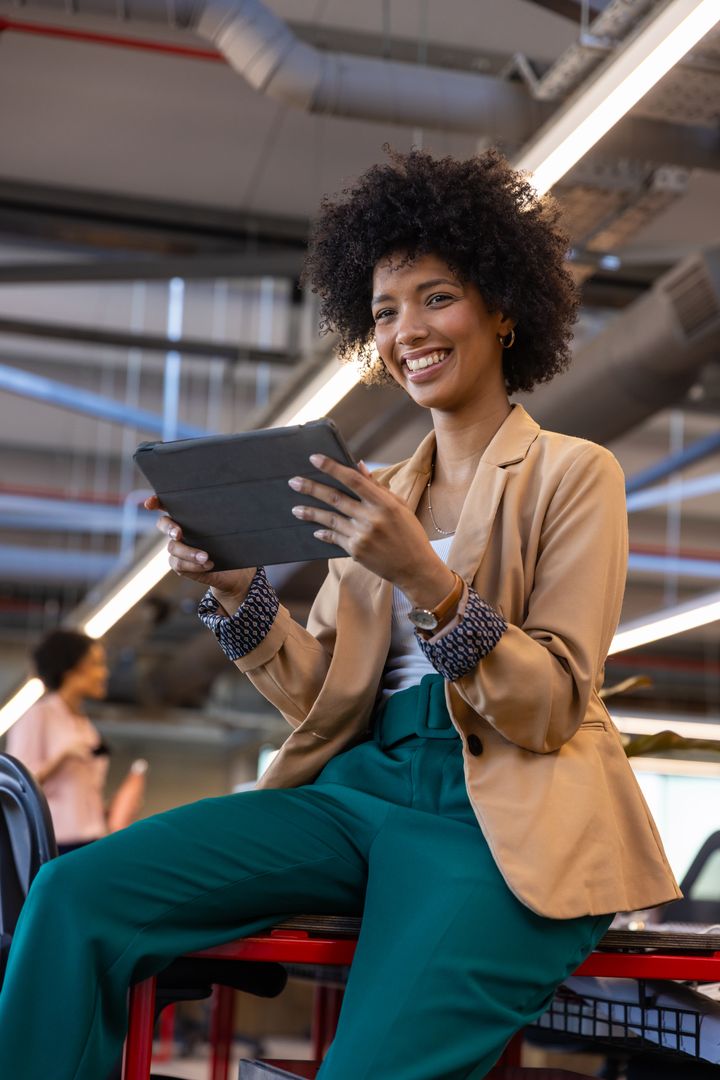Confident African American Professional Holding Tablet in Open Office