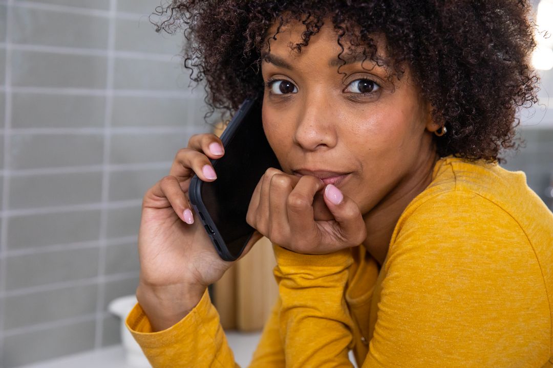 Woman Leaning on Counter Slotted While Talking on Smartphone