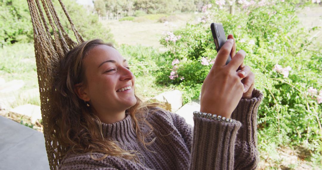 Smiling Woman Relaxing in Hammock Using Smartphone in Nature - Free Images, Stock Photos and Pictures on Pikwizard.com