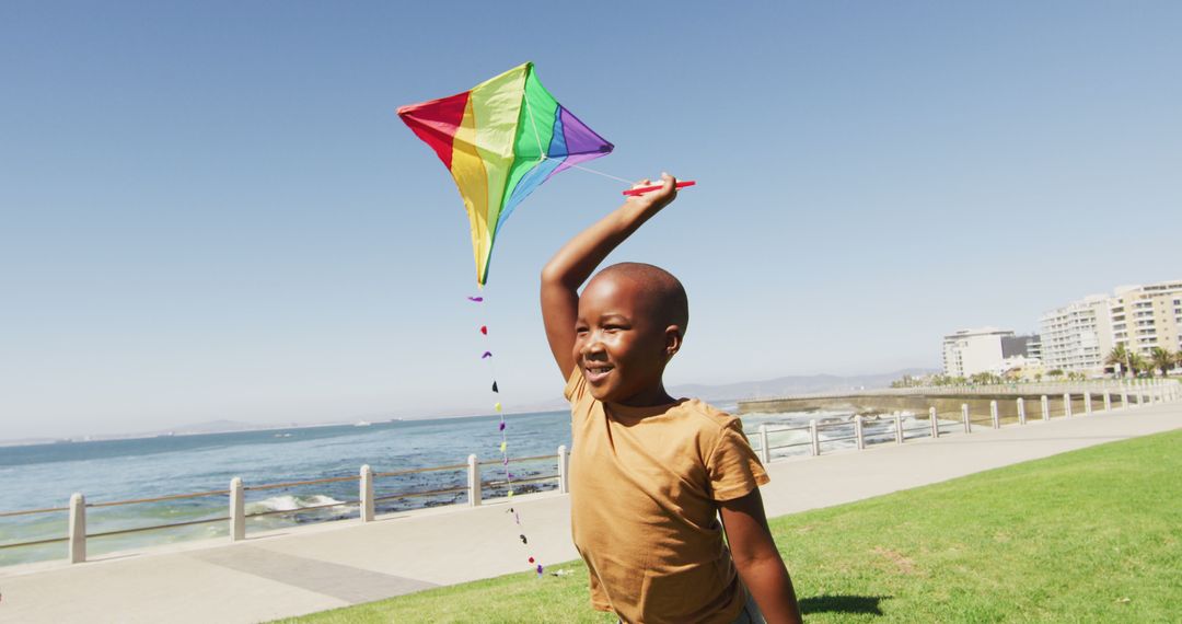 Joyful Child Flying Colorful Kite by the Oceanfront - Free Images, Stock Photos and Pictures on Pikwizard.com