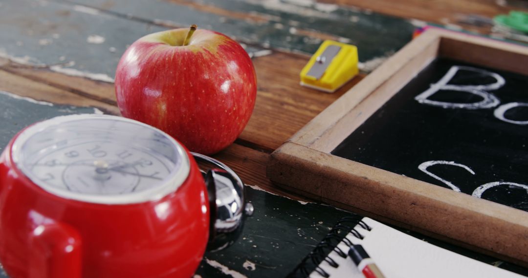 A red apple and alarm clock on a desk symbolize the essence of education and time management. - Free Images, Stock Photos and Pictures on Pikwizard.com