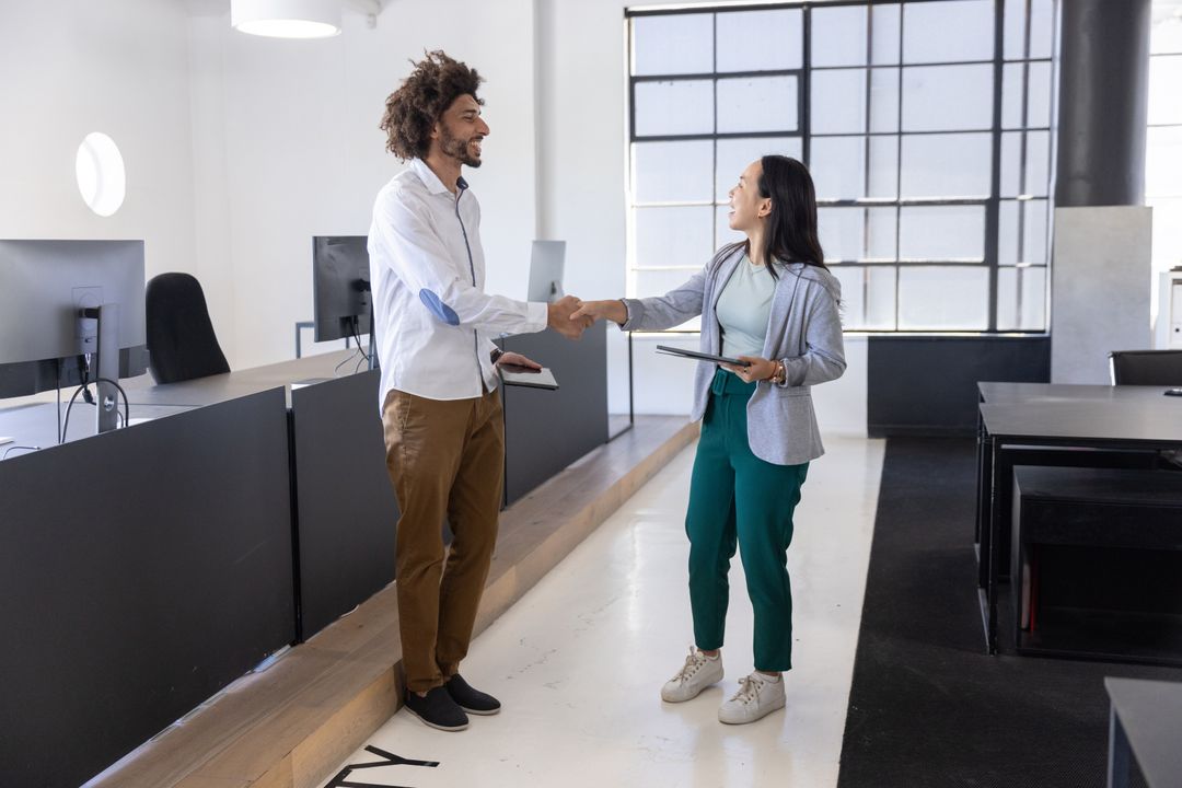 Diverse Coworkers Shaking Hands in Open-Plan Office