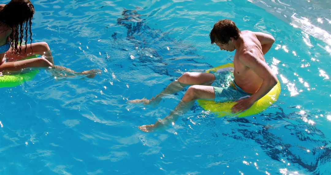 Couple Relaxing on Inflatable Tubes in Swimming Pool - Free Images, Stock Photos and Pictures on Pikwizard.com