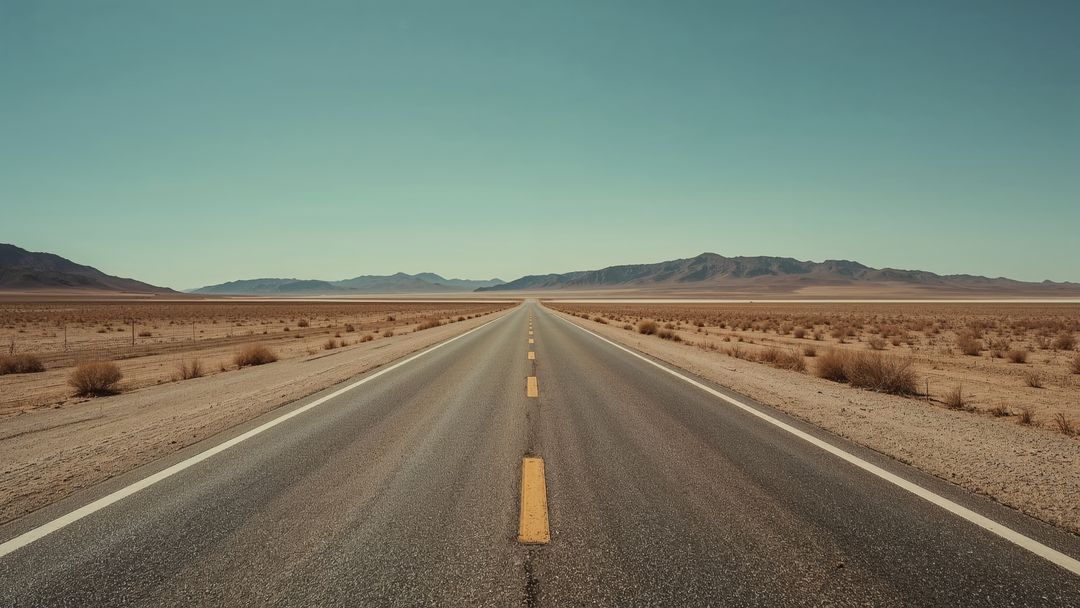 Endless Desert Highway with Dramatic Sky and Distant Mountains