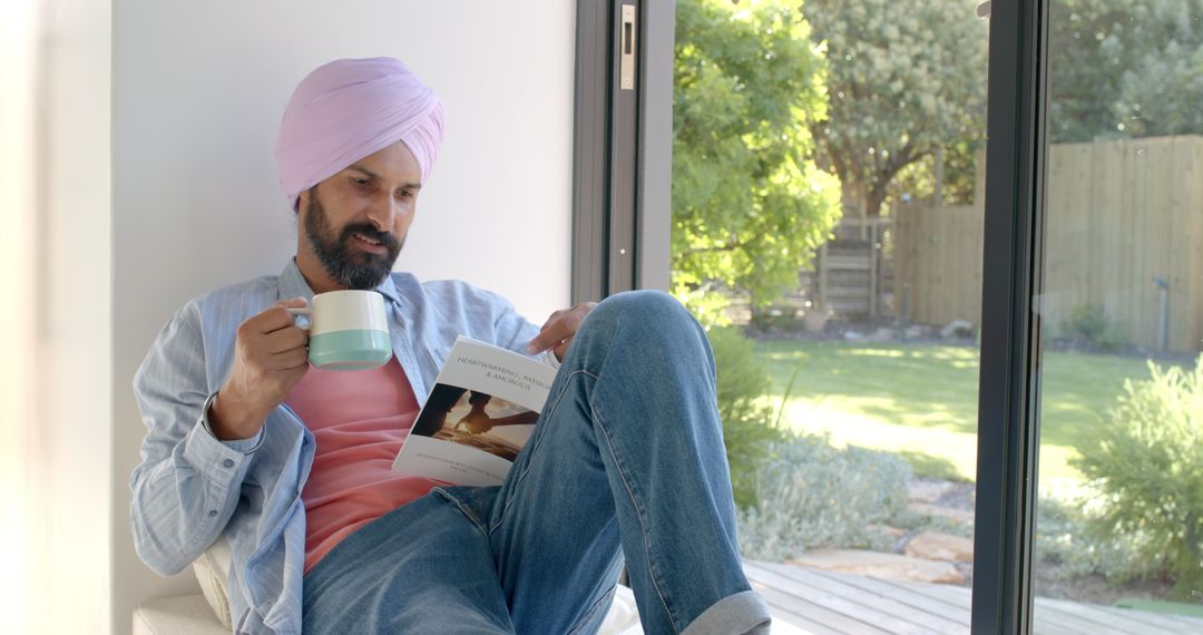 Man Relaxing at Home with Coffee and Magazine by Sunlit Window
