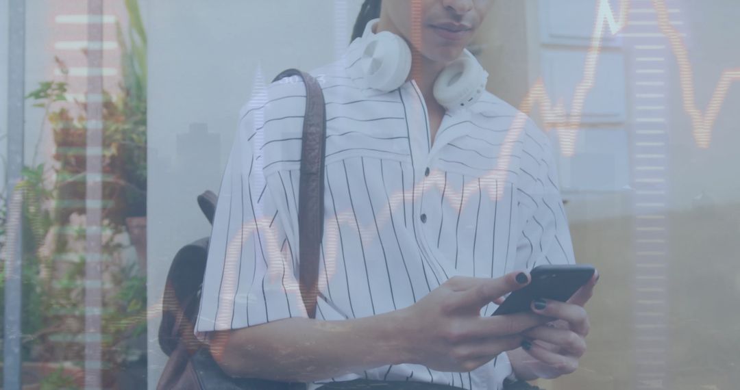 Biracial Man with Travel Bag Using Smartphone and Digital Graphs