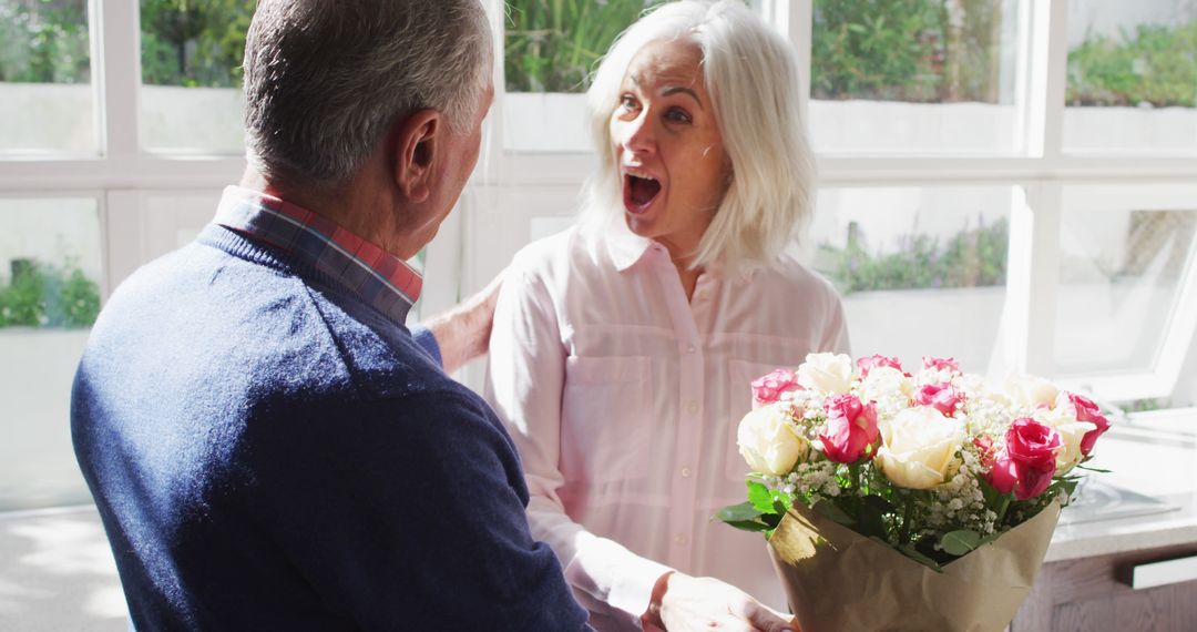 Elderly man surprising senior woman with bouquet of flowers - Free Images, Stock Photos and Pictures on Pikwizard.com