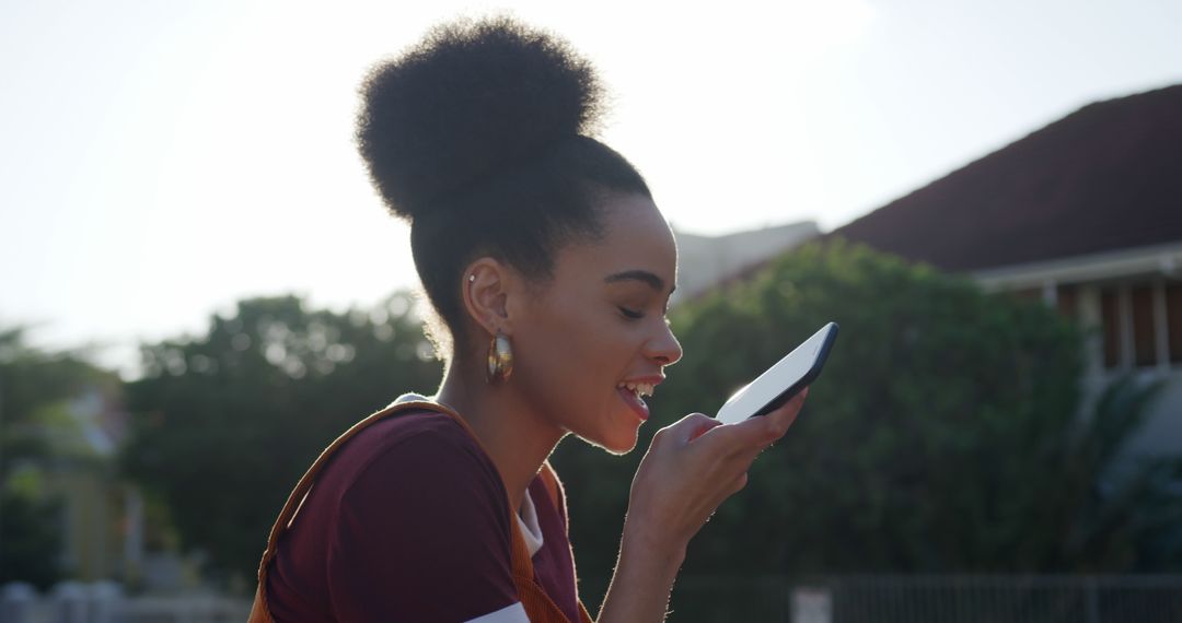 Young Woman Using Voice Command Feature on Smartphone Outdoors - Free Images, Stock Photos and Pictures on Pikwizard.com