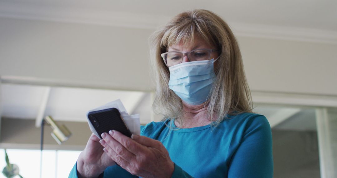 Senior Woman Calling Using Smartphone and Face Mask Indoors - Free Images, Stock Photos and Pictures on Pikwizard.com