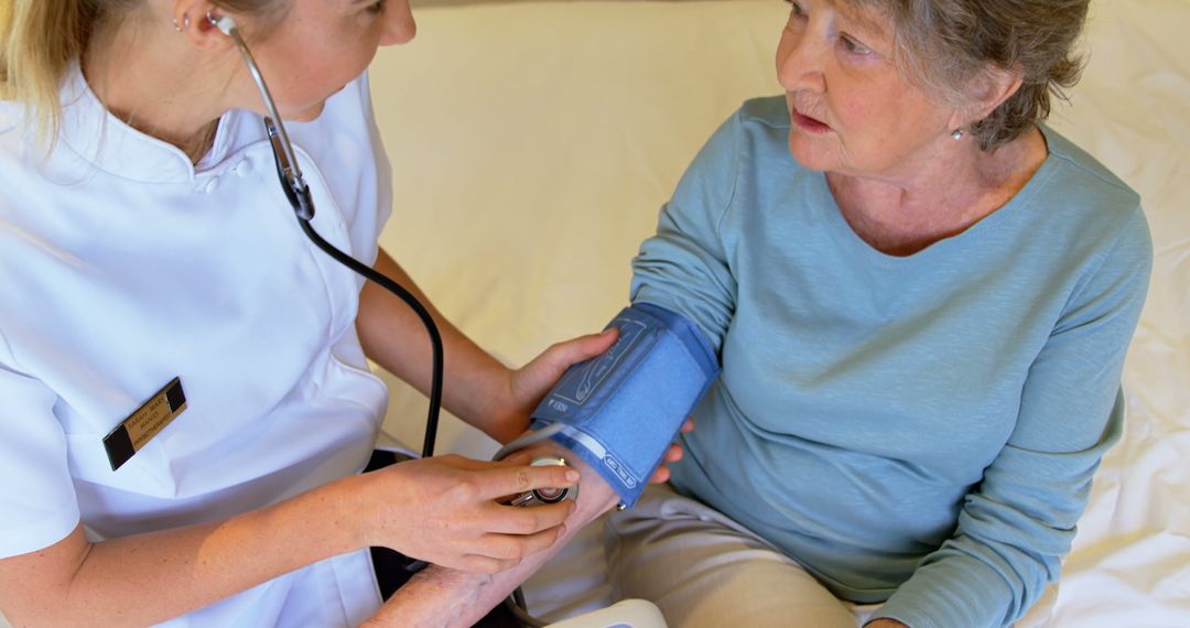 Nurse Taking Blood Pressure of Elderly Woman in Medical Setting - Free Images, Stock Photos and Pictures on Pikwizard.com