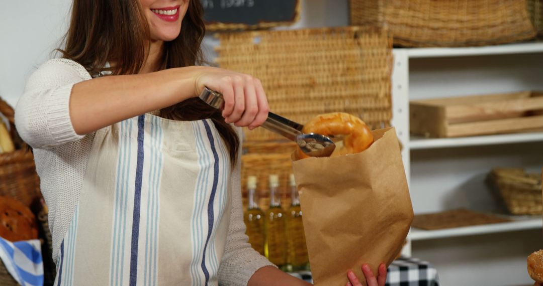 Smiling woman serving fresh bread in bakery - Free Images, Stock Photos and Pictures on Pikwizard.com