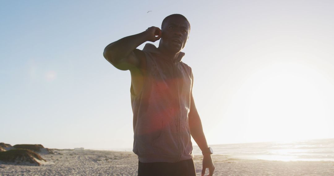 Athletic Man Stretching on Beach During Sunset - Free Images, Stock Photos and Pictures on Pikwizard.com