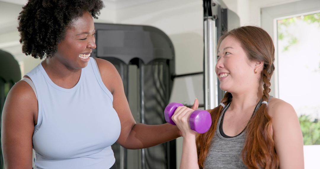 Fitness Trainer Guiding Client Lifting Dumbbells in Gym