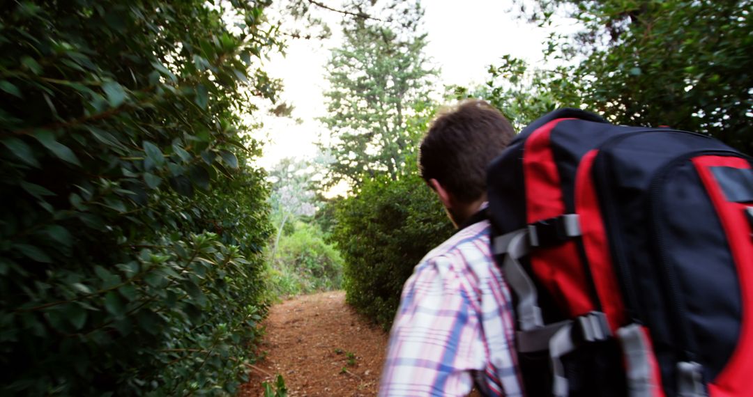 Backpacker Hiking Through Forest Path at Sunset