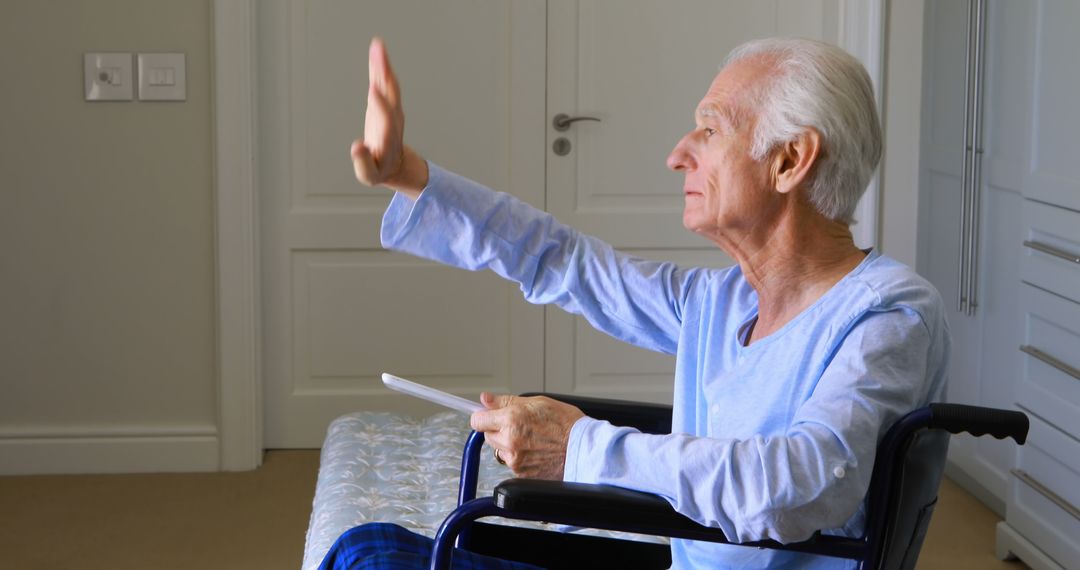 Elderly Man Waving and Sitting in Wheelchair Holding Book - Free Images, Stock Photos and Pictures on Pikwizard.com