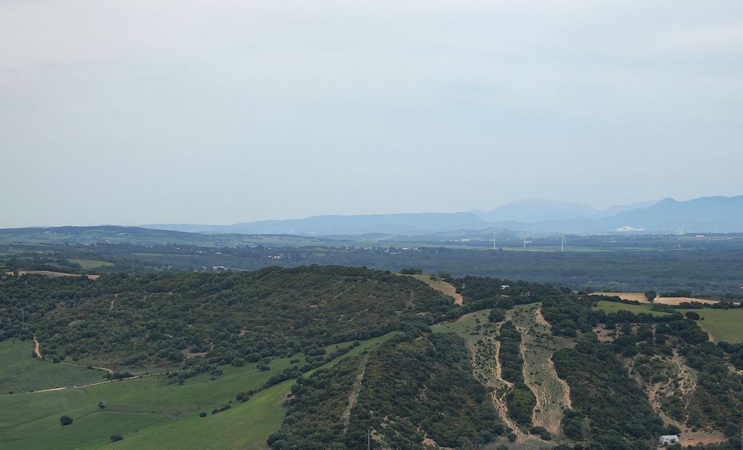 Scenic Green Hills and Distant Mountains under Cloudy Sky - Free Images, Stock Photos and Pictures on Pikwizard.com