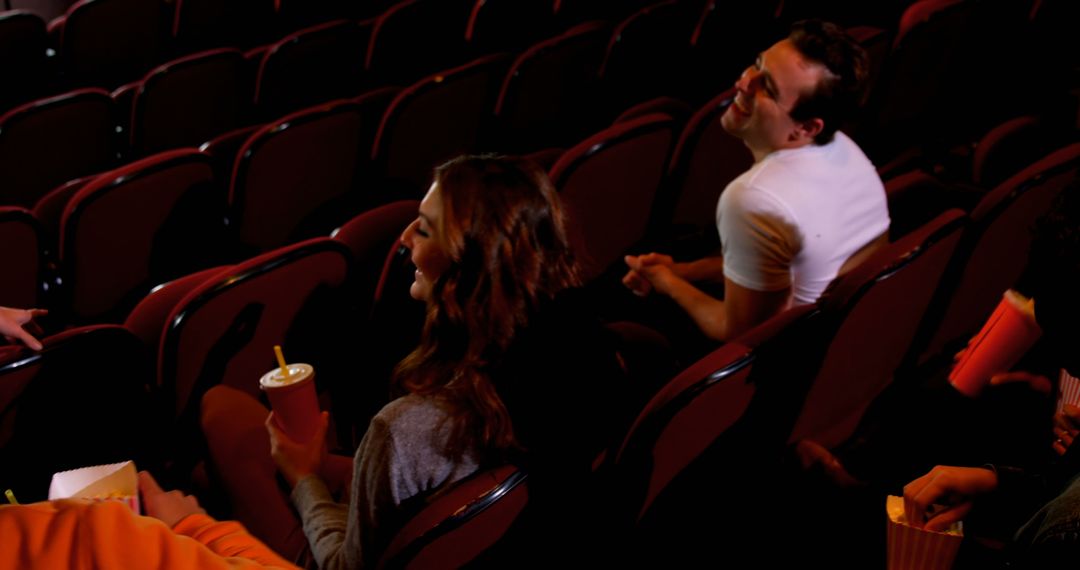 Friends Enjoying Movie in Theater with Snacks