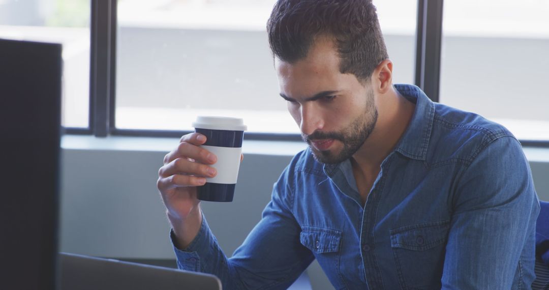 Casual Businessman Focused on Work with Coffee In Hand