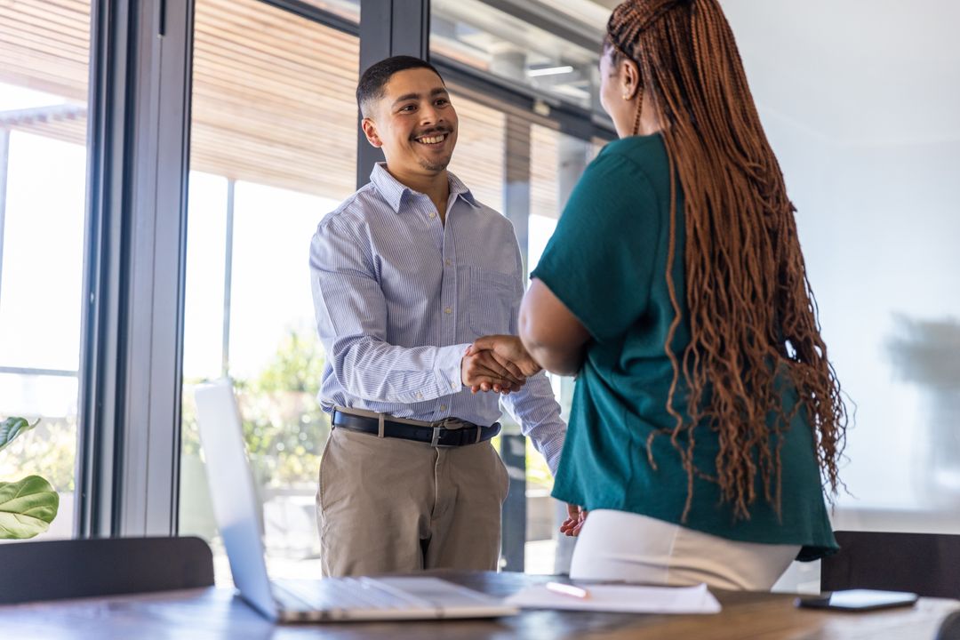 Professional Coworkers Shaking Hands in Modern Office Setting
